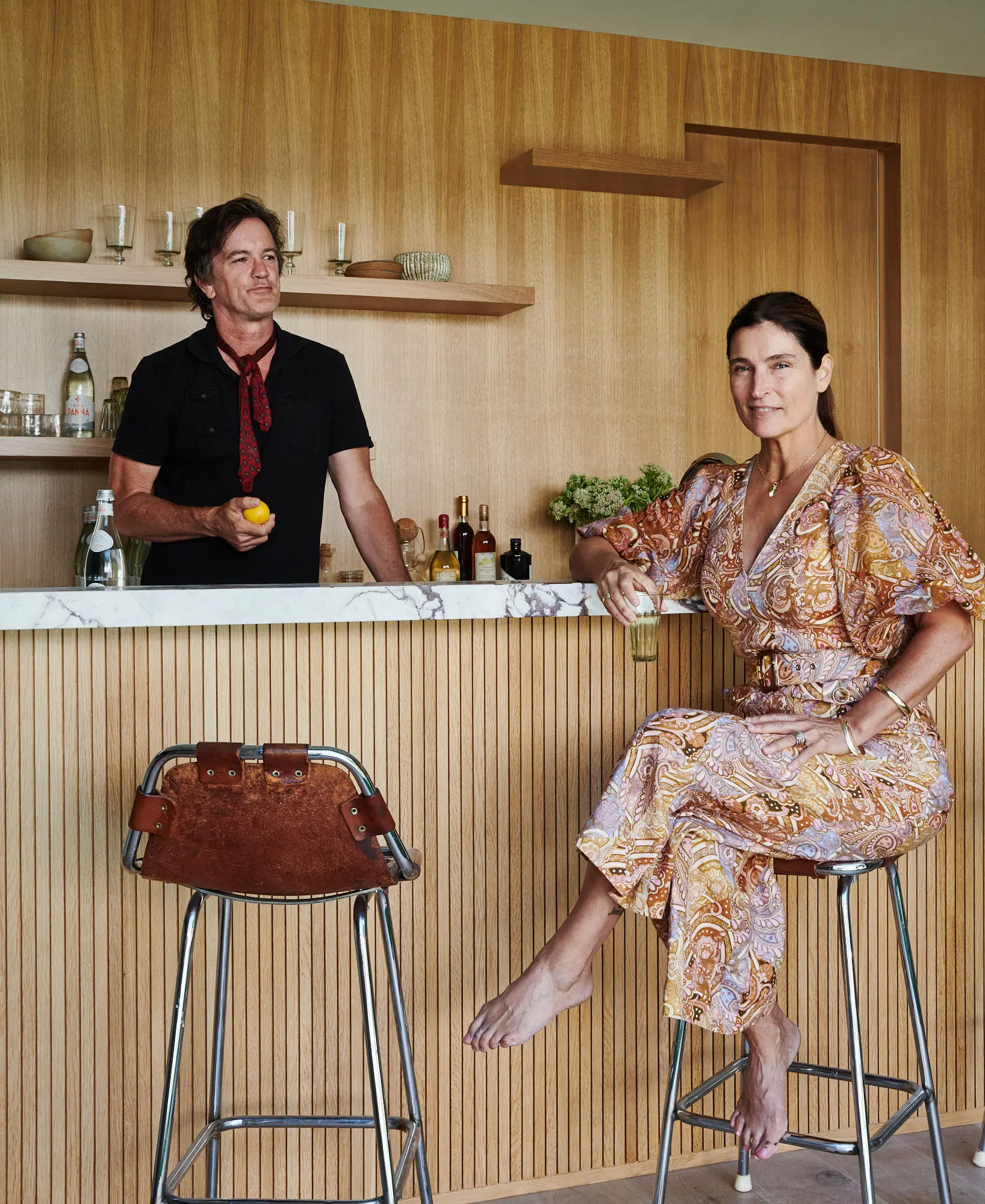 Robert and Cortney Novogratz are pictured in front of a modern, cozy bar.